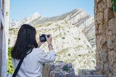 Attraktiv kvinnablogger som gör foto av härlig berglandsape arkivbilder Attraktiv kvinnablogger som gör foto av härlig berglandsape arkivbilder
