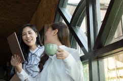 Attraktive Geschäftsfrau mit zwei Asiaten, die einen Kaffee trinkt und eine digitale Tablette verwendet lizenzfreie stockbilder Attraktive Geschäftsfrau mit zwei Asiaten, die einen Kaffee trinkt und eine digitale Tablette verwendet lizenzfreie stockbilder
