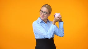 Attraktive junge Frau, die piggybank, Bankkonto, Finanzkapital, Spareinlagen rüttelt stock footage Attraktive junge Frau, die piggybank, Bankkonto, Finanzkapital, Spareinlagen rüttelt stock footage