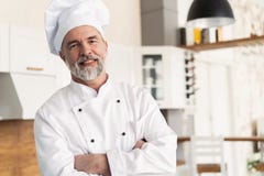 Attraktive kaukasische Chefstellung mit den Armen kreuzte in einer Restaurantk?che lizenzfreies stockbild Attraktive kaukasische Chefstellung mit den Armen kreuzte in einer Restaurantk?che lizenzfreies stockbild