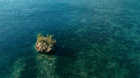 Aturdir imagen aérea del abejón de un filón colorido del fondo del mar con una roca del acantilado que se coloca fuera del agua e foto de archivo Aturdir imagen aérea del abejón de un filón colorido del fondo del mar con una roca del acantilado que se coloca fuera del agua e foto de archivo