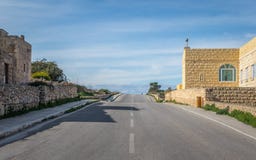 Até o horion Uma rua vazia, desigual ao horizonte quadro por algumas construções em Malta, em um dia nebuloso imagens de stock royalty free Até o horion Uma rua vazia, desigual ao horizonte quadro por algumas construções em Malta, em um dia nebuloso imagens de stock royalty free