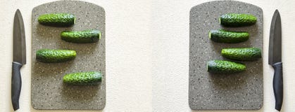 Auf einem weißen Hintergrund liegen vier Gurken auf einem Steinbrett, ein Messer sich befindet nahe bei ihm lizenzfreie stockbilder Auf einem weißen Hintergrund liegen vier Gurken auf einem Steinbrett, ein Messer sich befindet nahe bei ihm lizenzfreie stockbilder