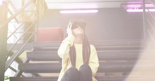 Aufgeregte Afrikanerdame entdecken die Gläser der virtuellen Realität sie sitzend auf der Treppe und das VR glückliche Beginnen z stock footage Aufgeregte Afrikanerdame entdecken die Gläser der virtuellen Realität sie sitzend auf der Treppe und das VR glückliche Beginnen z stock footage