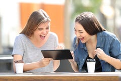 Aufgeregte Freunde, die Tabletteninhalt in einem Park aufpassen lizenzfreie stockfotografie Aufgeregte Freunde, die Tabletteninhalt in einem Park aufpassen lizenzfreie stockfotografie