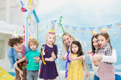 Aufgeregte Kinder, die fallende Konfettis von den Crackern betrachten lizenzfreies stockbild Aufgeregte Kinder, die fallende Konfettis von den Crackern betrachten lizenzfreies stockbild