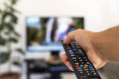 Aufpassendes Fernsehen und Anwendung der Fernbedienung stockbild Aufpassendes Fernsehen und Anwendung der Fernbedienung stockbild