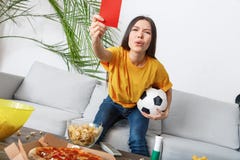 Aufpassendes Match des Sportfreunds der jungen Frau in einer gelbes T-Shirt roten Karte lizenzfreies stockbild Aufpassendes Match des Sportfreunds der jungen Frau in einer gelbes T-Shirt roten Karte lizenzfreies stockbild