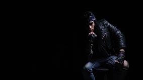 Aufstellung des Rockerkerls mit dem langen schwarzen Haar, tragender Lederjacke und ährentragenden Handschuhen, Zeitlupe stock video footage Aufstellung des Rockerkerls mit dem langen schwarzen Haar, tragender Lederjacke und ährentragenden Handschuhen, Zeitlupe stock video footage