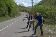 Augmentant les bâtons s'approchent de moi - faisant de l'auto-stop Touristes dans l'automatique-arrêt de route images libres de droits Augmentant les bâtons s'approchent de moi - faisant de l'auto-stop Touristes dans l'automatique-arrêt de route images libres de droits