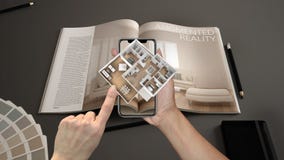 Augmented reality concept. Hand holding smartphone with AR application used to simulate 3d pop-up interactive house maps royalty free stock photo Augmented reality concept. Hand holding smartphone with AR application used to simulate 3d pop-up interactive house maps royalty free stock photo