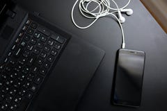 Auriculares del cuaderno del teléfono en la tabla negra imágenes de archivo libres de regalías Auriculares del cuaderno del teléfono en la tabla negra imágenes de archivo libres de regalías