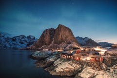 Aurora borealis sobre la montaña con el pueblo pesquero en Hamnoy fotos de archivo libres de regalías Aurora borealis sobre la montaña con el pueblo pesquero en Hamnoy fotos de archivo libres de regalías