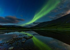 Aurora borealis w nocne niebo r?ni?tych g?rach, odbija? w wodzie zdjęcia royalty free Aurora borealis w nocne niebo r?ni?tych g?rach, odbija? w wodzie zdjęcia royalty free