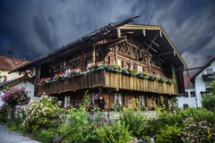 An authentic Bavarian Waldlerhaus with a lot of flowers in a garden