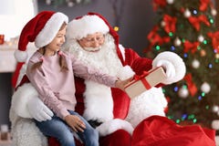 Authentic Santa Claus Giving Gift Box To Little Girl Stock Photo