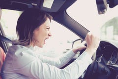 Autista femminile arrabbiato di profilo laterale che grida mentre conducendo la sua automobile immagini stock libere da diritti Autista femminile arrabbiato di profilo laterale che grida mentre conducendo la sua automobile immagini stock libere da diritti