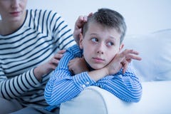 Autistiskt barn som ligger på soffan arkivbild Autistiskt barn som ligger på soffan arkivbild