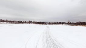 Autoaandrijving door ijzig spoor op sneeuw behandeld meer bij de winter Lucht Mening Sportwagen die op het spoor van het sneeuwra stock footage Autoaandrijving door ijzig spoor op sneeuw behandeld meer bij de winter Lucht Mening Sportwagen die op het spoor van het sneeuwra stock footage