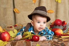 Autumn concept - child boy lie on yellow leaves with fruits and vegatbles, red apples and pumpkins stock images Autumn concept - child boy lie on yellow leaves with fruits and vegatbles, red apples and pumpkins stock images