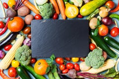 Autumn farm vegetables, root crops and slate cutting board top view with copy space for menu or recipe. Healthy food background.