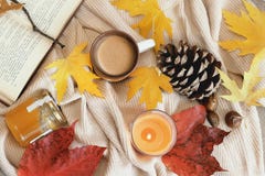 Autumn frame flat lay composition on a beige wool background. Maple leaves, season coffe, open book, orange aromatic candle, pinec royalty free stock photography Autumn frame flat lay composition on a beige wool background. Maple leaves, season coffe, open book, orange aromatic candle, pinec royalty free stock photography