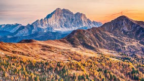 Autumn landscape with yellow larches and spectacular Monte Civetta at  sunset