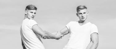 Avantages de avoir le fr?re jumeau Amiti? et appui Fr?res de jumeaux musculaires d'hommes ? l'arri?re-plan blanc de ciel de chemi photographie stock Avantages de avoir le fr?re jumeau Amiti? et appui Fr?res de jumeaux musculaires d'hommes ? l'arri?re-plan blanc de ciel de chemi photographie stock