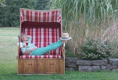Avec Stetson comme protection solaire ses pieds, une boisson et un suncream rouge ainsi la femme attirante apprécie le jour dans image stock Avec Stetson comme protection solaire ses pieds, une boisson et un suncream rouge ainsi la femme attirante apprécie le jour dans image stock