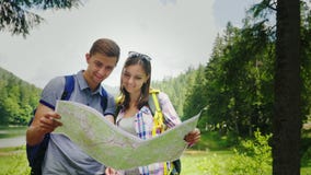 Aventuras nas montanhas Olhar novo dos turistas em seu mapa de lugar video estoque Aventuras nas montanhas Olhar novo dos turistas em seu mapa de lugar video estoque