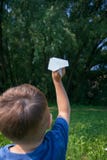Avion de papier chez des mains des enfants sur le fond de verdure et ciel bleu dans le jour d'été ensoleillé Concept d'été, enfan images stock Avion de papier chez des mains des enfants sur le fond de verdure et ciel bleu dans le jour d'été ensoleillé Concept d'été, enfan images stock