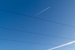 Avions dans un ciel bleu avec les contrails blancs derrière eux fils électriques croisés Norilsk image stock Avions dans un ciel bleu avec les contrails blancs derrière eux fils électriques croisés Norilsk image stock