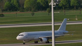 Avión blanco que hace el taxi en el aeropuerto de Munich, hierba verde Avión blanco que hace el taxi en el aeropuerto de Munich, hierba verde