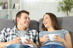 Avkopplade par som talar och rymmer kaffekoppar arkivbild Avkopplade par som talar och rymmer kaffekoppar arkivbild