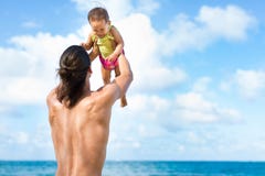 Avla att kasta hans barn playfully på stranden fotografering för bildbyråer Avla att kasta hans barn playfully på stranden fotografering för bildbyråer