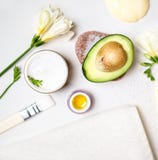 Avocado und Glas von Sahneöllilienblumen und von weißem Tuch der Seesalzseife auf einem weißen Hintergrund Avocadohautpflege-Gesi stockbilder Avocado und Glas von Sahneöllilienblumen und von weißem Tuch der Seesalzseife auf einem weißen Hintergrund Avocadohautpflege-Gesi stockbilder
