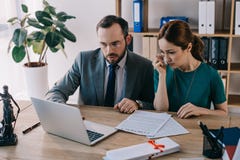 avocat et client pleurant discutant le contrat sur le lieu de travail avec l'ordinateur portable photos libres de droits avocat et client pleurant discutant le contrat sur le lieu de travail avec l'ordinateur portable photos libres de droits