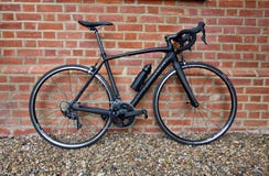 28 avril 2019 - Londres, Royaume-Uni : Position noire élégante de bicyclette contre le mur de briques superficiel par les agents photo libre de droits 28 avril 2019 - Londres, Royaume-Uni : Position noire élégante de bicyclette contre le mur de briques superficiel par les agents photo libre de droits