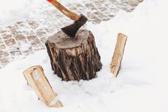 Ax sticks out in stump against background of white snow stock photography Ax sticks out in stump against background of white snow stock photography