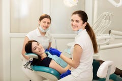 Ayudante de la pizca del doctor que trata los dientes del paciente, previniendo la carie Concepto de la estomatolog?a imagen de archivo libre de regalías Ayudante de la pizca del doctor que trata los dientes del paciente, previniendo la carie Concepto de la estomatolog?a imagen de archivo libre de regalías