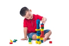 Aziaat weinig jongen die met kleurrijke die blokken spelen, op wit worden geïsoleerd royalty-vrije stock afbeelding Aziaat weinig jongen die met kleurrijke die blokken spelen, op wit worden geïsoleerd royalty-vrije stock afbeelding