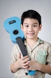 Aziatisch kind met zijn ukelele royalty-vrije stock afbeeldingen Aziatisch kind met zijn ukelele royalty-vrije stock afbeeldingen