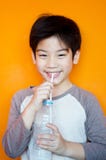 Aziatische jongen met fles water royalty-vrije stock afbeelding Aziatische jongen met fles water royalty-vrije stock afbeelding