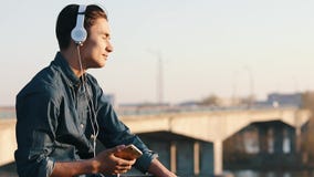 Aziatische mengen-ras donkerbruine tiener die aan muziek met zijn hoofdtelefoons luisteren stock video Aziatische mengen-ras donkerbruine tiener die aan muziek met zijn hoofdtelefoons luisteren stock video