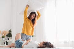 Aziatische speel het hoofdkussenvlucht van de lesbainvrouw samen op bed in whi royalty-vrije stock afbeelding Aziatische speel het hoofdkussenvlucht van de lesbainvrouw samen op bed in whi royalty-vrije stock afbeelding