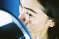 Aziatische vrouw die schoonheidsmiddelenmake-up toepassen en de camouflagestift van de kleurencorrectie gebruiken stock afbeeldingen Aziatische vrouw die schoonheidsmiddelenmake-up toepassen en de camouflagestift van de kleurencorrectie gebruiken stock afbeeldingen