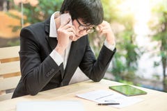 Aziatische zakenman die telefoon met behulp van die rapport bekijken stock afbeelding Aziatische zakenman die telefoon met behulp van die rapport bekijken stock afbeelding