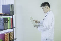 Azjatyckich potomstw mienia doktorski trwanie laptop znajdować pracy informację, stetoskopu obwieszenie na szyi zdjęcia royalty free Azjatyckich potomstw mienia doktorski trwanie laptop znajdować pracy informację, stetoskopu obwieszenie na szyi zdjęcia royalty free