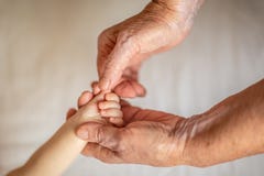 Babcia trzyma rękę jej nowonarodzony wnuk pojęcie ochrona i opieka nowe pokolenie zdjęcia stock Babcia trzyma rękę jej nowonarodzony wnuk pojęcie ochrona i opieka nowe pokolenie zdjęcia stock