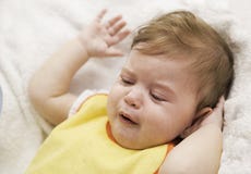 The baby in a bip is crying and refuses to eat. Child`s hysterics. Closeup portrait of crying baby stock photos The baby in a bip is crying and refuses to eat. Child`s hysterics. Closeup portrait of crying baby stock photos